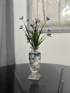 塞雷Serres city center modern apartment (Monika)的玻璃瓶,桌子上装有紫色花
