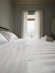 维蒂纳Methydrion Country House的卧室配有一张大白色床和窗户
