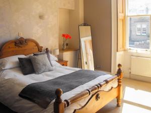 AllantonPurves Cottage的一间卧室配有一张带枕头的大型木制床。
