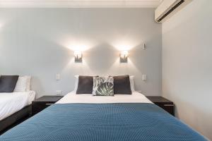 Old Reynella圣弗朗西斯酒厂酒店的一间卧室配有两张床,墙上有两盏灯