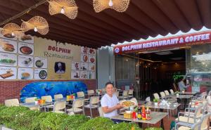 吉婆岛Dolphin Hotel的坐在餐厅前桌边的人