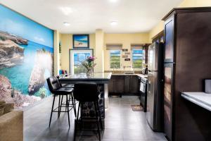 Island HarbourElleamau的厨房设有带凳子和冰箱的酒吧。