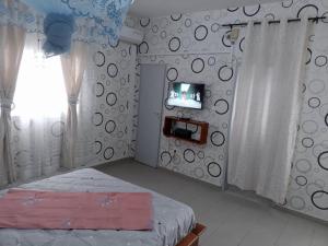 杜阿拉Partners Residence的一间卧室配有一张床,墙上配有电视