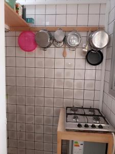 杜阿拉Partners Residence的厨房设有瓷砖墙,配有锅碗瓢盆