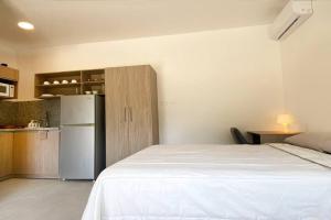 圣埃莱纳Estudio 1, Las Castañas的卧室配有白色的床和冰箱。