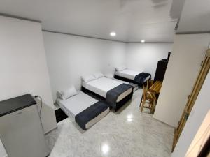 麦德林Apartahotel Sevilla的一间设有两张床和一台电视的房间