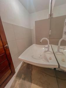 加利纽斯Chalé Galo Preto的白色的浴室设有水槽和镜子