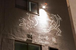 神户かゑる屋的建筑的侧面有白色涂鸦