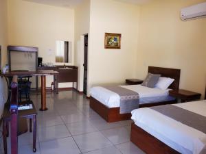 La GaritaVilla Garita Inn的酒店客房配有两张床和一张书桌