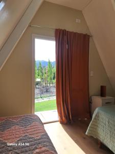 门多萨Cabañas Alpinas的一间卧室设有一张床和一个大窗户