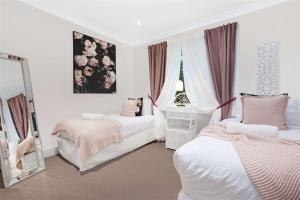 BarrengarryPaddington Cottage, Kangaroo Valley的一间卧室配有两张床和镜子