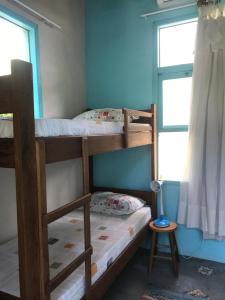 普腊亚罗萨Paikea Hostel Praia do Rosa的带窗户的客房内的两张双层床