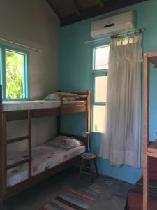 普腊亚罗萨Paikea Hostel Praia do Rosa的一间卧室设有两张双层床和一扇窗户。