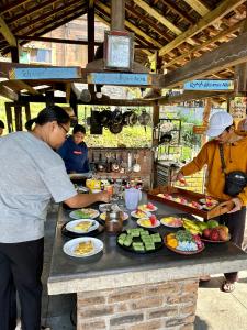 贾蒂卢维Oemah Tepi Sawah的一群人在餐桌上准备食物