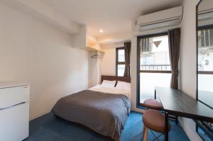 东京KandO Hostel Ueno的一间小卧室,配有一张床和一张书桌