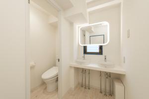 东京KandO Hostel Ueno的白色的浴室设有卫生间和镜子