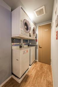 东京KandO Hostel Ueno的洗衣房配有洗衣机和烘干机