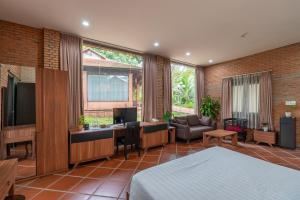 Ấp Thanh NguyênMekong Long Thanh Resort & Reststop的一间卧室配有一张床和一张书桌及电视