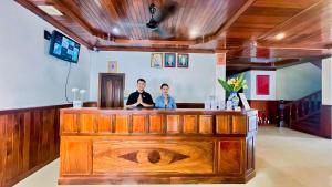 暹粒Harmony Indochine d'Angkor的两个人站在一间房间里酒吧
