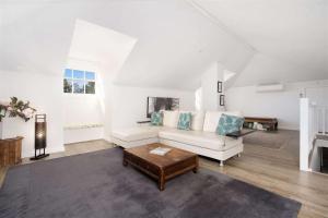 袋鼠谷Myrtle Tree Lodge Leaves, Kangaroo Valley的客厅配有白色沙发和茶几