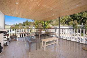 袋鼠谷Myrtle Tree Lodge Leaves, Kangaroo Valley的露台设有桌子和长凳