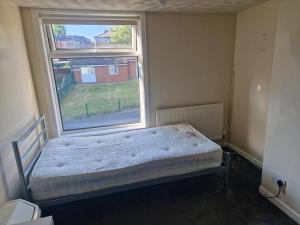 罗奇代尔Cozy Bedroom in Spacious House Manchester的卧室在窗户前配有一张床