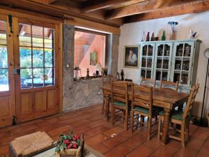 塞尔塞迪利亚La Casa Bonita Cercedilla的一间带木桌和椅子的用餐室