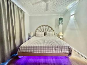 UtakarraThe Wildflower- Luxury Home Stay的一间卧室配有一张紫色灯床