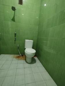 帕朗卡拉亚OYO 93343 Sukma Residence的绿色瓷砖浴室设有卫生间和淋浴。