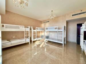 迪拜AR Holiday Home JBR 2的客房设有四张双层床和吊灯。