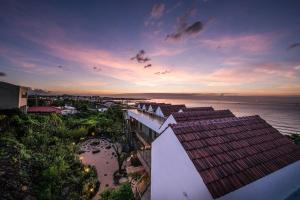 济州市Yaho Beach House的享有大楼和日落海景