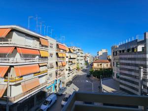 拉里萨Elektras Apartment στο κέντρο της Λάρισας με δωρεάν πάρκιγκ的享有城市美景,在街道上停放汽车