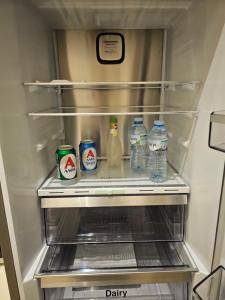 拉里萨Elektras Apartment στο κέντρο της Λάρισας με δωρεάν πάρκιγκ的装满奶瓶和水的冰箱