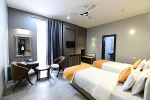 菩提伽耶Hotel Jataka Inn的酒店客房配有两张床和一张书桌