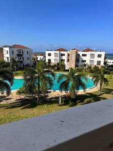 基利菲TAUSI HOMES Sultan Palace Beach Resort的享有棕榈树和建筑的游泳池景色