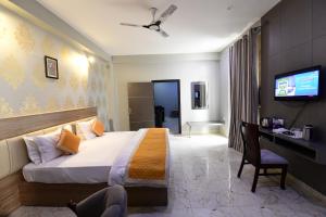 菩提伽耶Hotel Jataka Inn的酒店客房设有一张床、一张书桌和一台电视机。