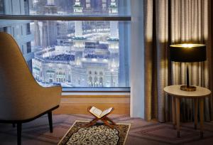 麦加Jumeirah Jabal Omar Makkah的客房设有窗户、书籍和椅子