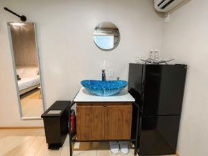 Sonai与那国むんぶステイ空港前的一间带水槽和黑色冰箱的浴室