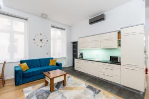 克拉科夫BlueApart with Terrace的一间带蓝色沙发的客厅和一间厨房