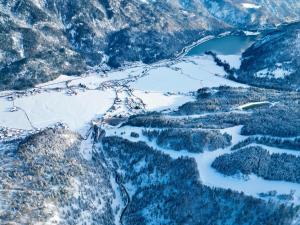 阿亨基希loisi's Boutiquehotel的享有白雪 ⁇ 的山谷和湖泊的空中景色