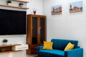 克拉科夫BlueApart with Terrace的客厅配有蓝色椅子和电视