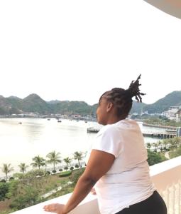 吉婆岛Cat Ba Central的站在一个眺望着水面的阳台上的女人