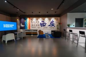 西安Sifang Space Hostel Xi'an - Xi'an KEJIDAXUE metro Line4的一间配有电视的房间和一个带标志的墙壁