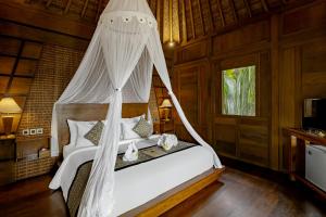 乌布Anandari Ubud Villa的一间卧室配有一张带蚊帐的床