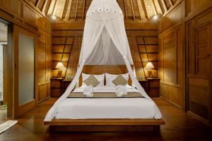 乌布Anandari Ubud Villa的一间卧室配有一张带蚊帐的床