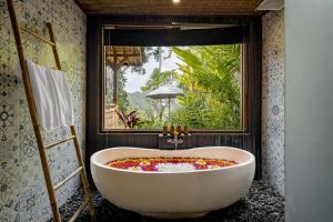 乌布Anandari Ubud Villa的带浴缸的浴室和窗户