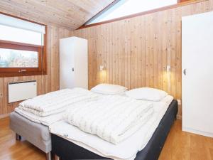 森讷比Three-Bedroom Holiday home in Juelsminde 17的木墙客房内的一张大床