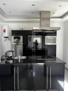 ÓrgãosVILLA NAYELI Luxury and Simplicity的厨房配有黑色和不锈钢用具