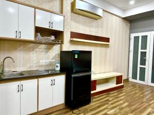 胡志明市Homestay Linh的厨房配有黑色冰箱和水槽