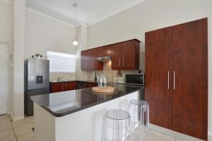 开普敦Apartment in Century City的厨房配有木制橱柜和不锈钢用具
